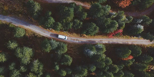 Ein Vanever Van ist von oben auf einer Straße in Tirol zu sehen.