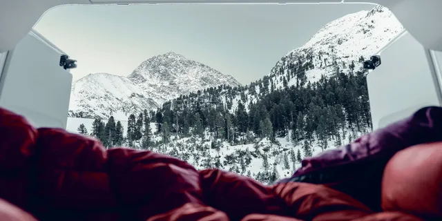 View on snowy mountains from inside a camper