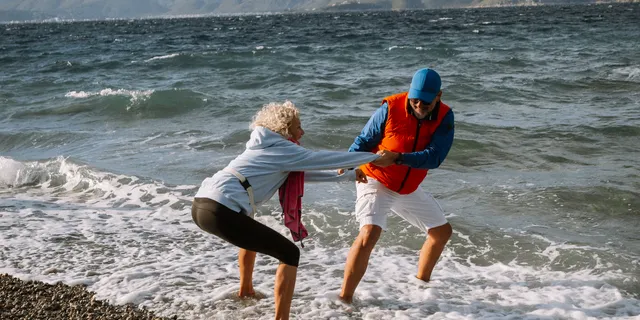 An older couple plays in the sea