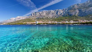 Clear sea water in front of Makarska on the coast of Croatia with mountains in the background on a holiday in Croatia