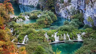 View from above on the Plitvice lakes with waterfalls and green landscape: Secret tip for your Croatia road trip with the camper