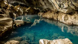 Die Höhle Grjótagjá auf Island mit klarem, türkisblauen Wasser