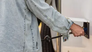 RV Clean freshwater tank: A person in jeans jacket emptys the water tank before she can clean it.