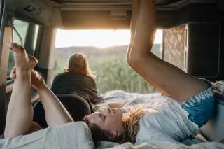 Girlfriends lie in bed from camper