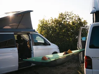 One person is located at Camping am Bannwaldsee in a hammock stretched between two campers.