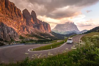 A VW Camper runs a curvy mountain road.