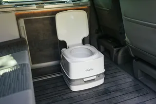 A portapotti is in the interior of a camper. You can find out how to dispose of chemical toilets in this article.