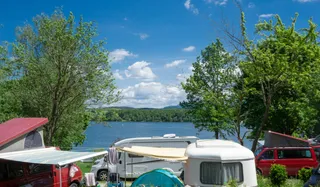 The campsite Brugger am Riegsee: campers and campers are located directly on the banks of the Riegsee between trees
