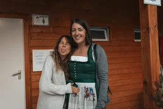 Zwei Frauen in Tracht lächeln in die Kamera eine streckt ihre Zunge heraus
