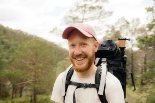 A man walking in Norway laughs in the camera.