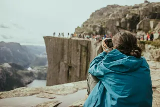A photographer makes pictures of a group of people on the Preikestolen.