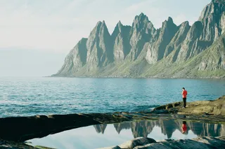 Senja in Norway, a man standing on the coast, you see mountains and sea. In this article we introduce you beautiful places in Norway.