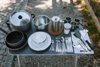 Campingtisch mit Küchenutensilien.