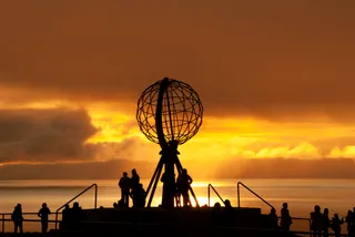 People looking at the midnight sun at a viewing platform