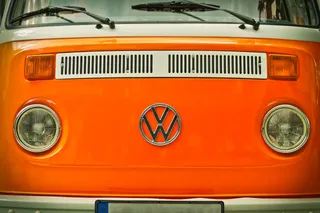 Organgener VW Bulli Campervan von vorne mit altem VW Logo